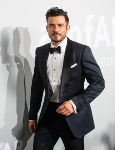 a man in a tuxedo poses for the camera