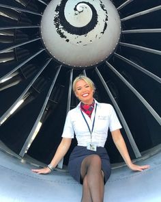 a woman sitting in front of an airplane engine