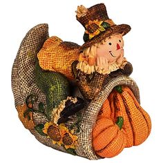 a small scarecrow sitting on top of a basket filled with pumpkins