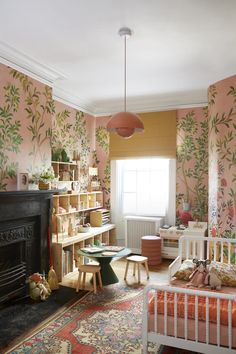 a living room filled with furniture and a fire place in front of a wallpapered wall