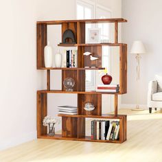 a wooden shelf with books and vases on it in the corner of a room