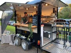 the food truck is parked on the side of the road and has an awning over it