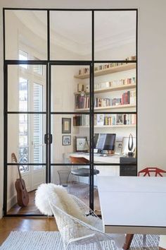 a living room filled with furniture and a book shelf next to a window covered in books