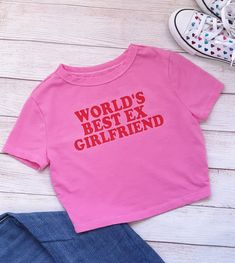 NEW! "World's Best Ex Girlfriend" Crop Top/Baby Tee is perfect for YOU!  This simple design says it all, without saying too much. It is perfect with your favorite pair of jeans or that cute mini skirt! High heels or tennis shoes, you can't go wrong with this baby tee!  Order a size up for a loose fit.  Machine wash is okay! Please HANG DRY! T-shirts are hand dyed and can slightly bleed after the first wash. Please wash with like colors. Design should outlast the t-shirt but if there is any lifting of the decal, cover design with parchment paper and press with a hot iron. College Gameday Outfits, Ex Gf, Crop Top For Women, Graphic Baby Tee, Girlfriend Shirts, Baby Crop Top, Baby Graphic Tees, Bridesmaid Proposal Gifts, Cute Crop Tops