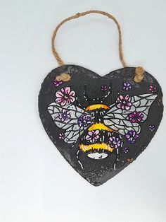 a heart shaped hanging decoration with butterflies on it's face and the words bee