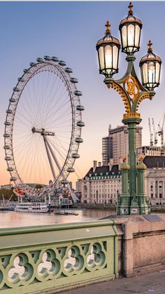 a large ferris wheel sitting on the side of a river