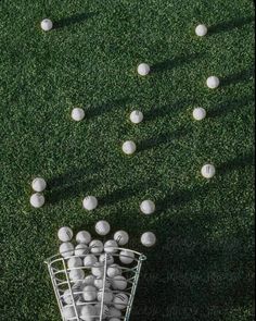 a basket full of baseballs sitting on top of a green grass covered soccer field