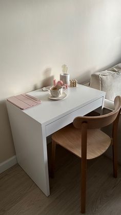 a white table with two chairs and a bowl on it in front of a window