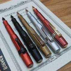 several pens are lined up next to each other on top of a piece of paper