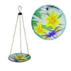 a glass plate with flowers hanging from it's side next to a metal chain