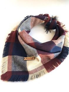 a plaid scarf with fringes on the end and a name tag hanging from it