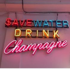 a neon sign that says save water drink champagne