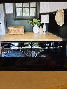 a flat screen tv sitting on top of a wooden table next to a dryer