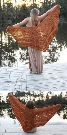 a woman sitting on top of a wooden dock next to water wearing an orange shawl