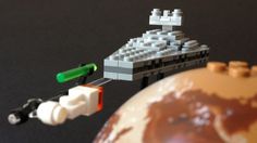 a lego model is shown next to an earth globe with a ship in the background