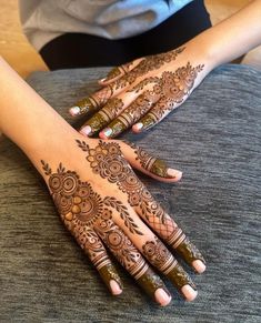 a woman's hands with henna tattoos on them