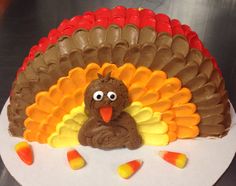 a cake shaped like a turkey sitting on top of a white plate with candy candies