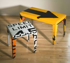 a yellow table sitting on top of a wooden floor next to a black and white sign