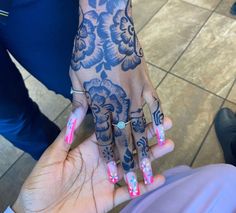 a woman with pink and blue nails holding her hand up to the camera while she is wearing