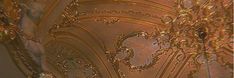 an ornate ceiling with intricate designs and gold paint