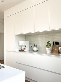 a kitchen with white cabinets and counter tops