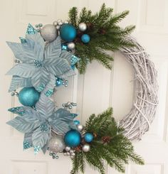 a wreath with blue and silver ornaments hanging on the front door