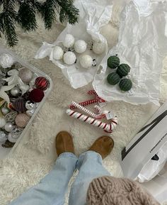 a person is laying on the floor with christmas decorations and candy canes in their hands