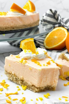 two slices of cheesecake with oranges on the side