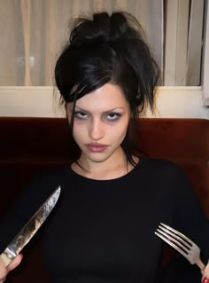 a woman holding a knife and fork in her hand