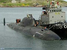 a black submarine floating on top of a body of water