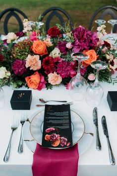 the table is set with flowers and silverware