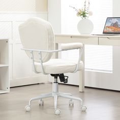 a white office chair sitting in front of a desk with a laptop computer on it