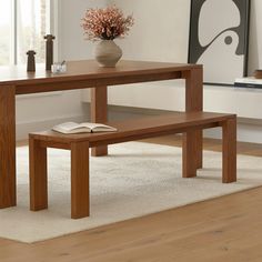 a wooden table with a book and vase on it