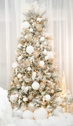 a white christmas tree with gold and silver ornaments