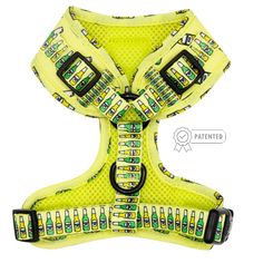 a yellow dog harness with green cars on the front and bottom, attached to it's collar