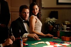 a man and woman sitting at a casino table