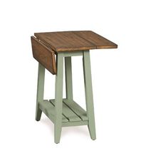 a small wooden table sitting on top of a white floor next to a green shelf