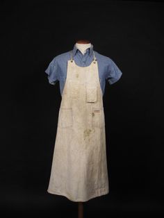 an old white apron on a mannequin with blue collared shirt and jeans