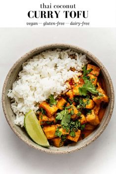 a bowl filled with rice and chicken next to a lime slice on top of it