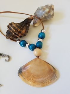 two seashells and a necklace on a white surface