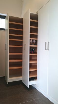 an empty room with white cabinets and brown tile flooring