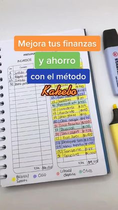 an open notebook with spanish words on it next to a marker and pen, along with other office supplies