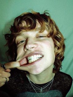 a young man making a silly face with his teeth wide open and tongue out to the side