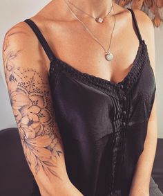 a woman with tattoos on her arm sitting down