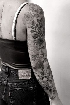 black and white photograph of a woman with tattoos on her arm, back to the camera