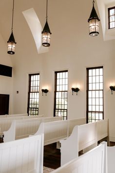 the interior of a church with white pews and stained glass windows