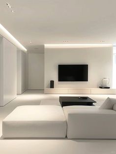 a living room with white furniture and a flat screen tv mounted on the wall above it