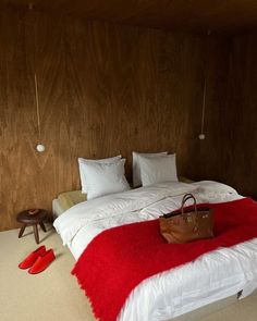 a red and white bed in a room with wooden walls