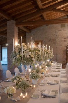 a long table is set with candles and flowers for an elegant wedding reception at the winery