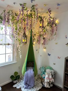 a hammock with purple flowers hanging from it's ceiling in a child's room